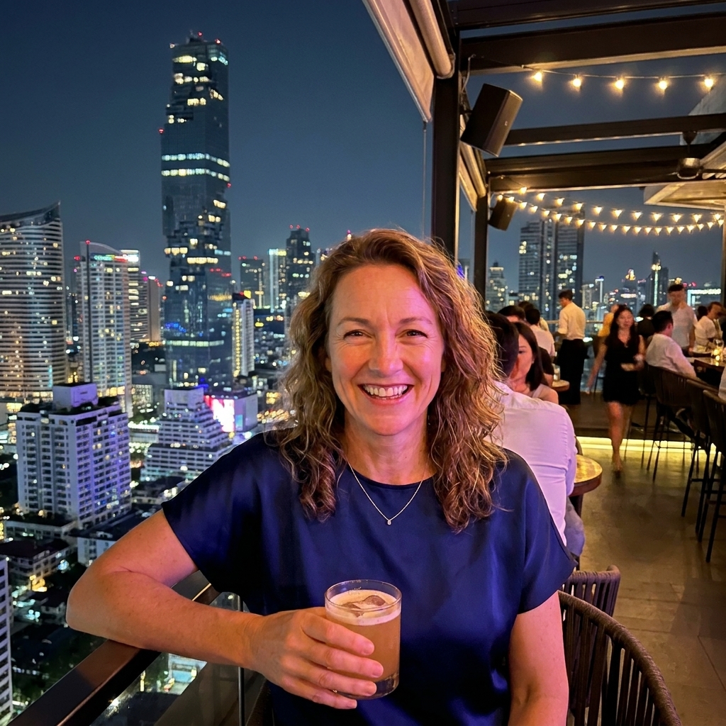 An open-air rooftop bar in Bangkok with a dramatic edge-of-the-building terrace and a glittering city skyline at night