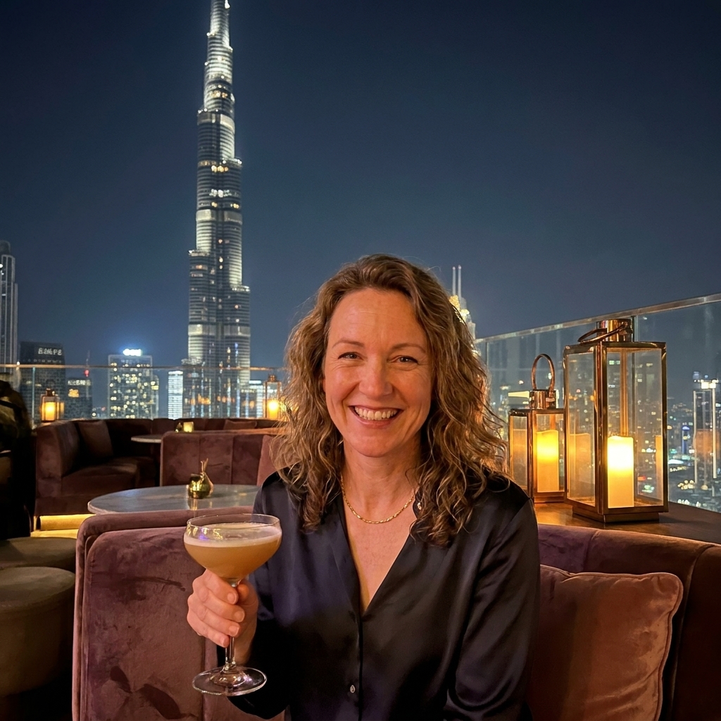 An-upscale rooftop lounge in Dubai with plush seating and the Burj Khalifa towering in the background at night